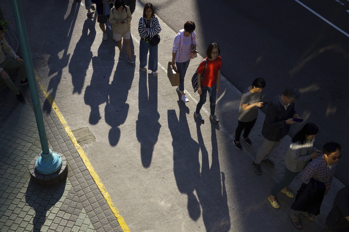 People line up to vote outside of a polling place in Hong Kong, Sunday, Nov. 24, 2019. Long lines formed outside Hong Kong polling stations Sunday in elections that have become a barometer of public s ...