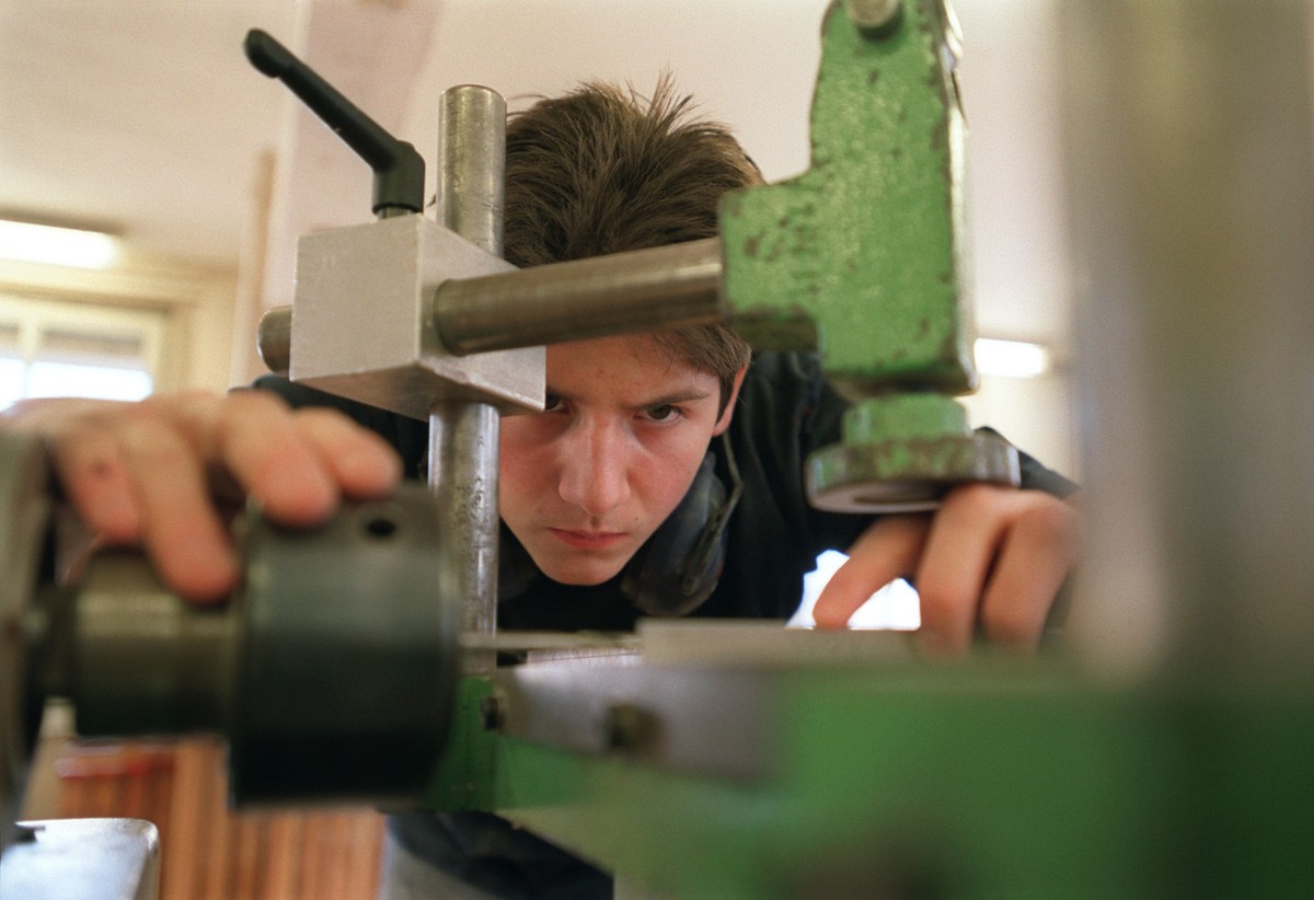 Ein Lehrling bei der Arbeit an der Maschine im Unterricht an der Abteilung Lehrwerkstaette fuer Moebelschreiner an der baugewerblichen Berufsschule Zuerich, aufgenommen am 4. Maerz 2003. (KEYSTONE/Gae ...