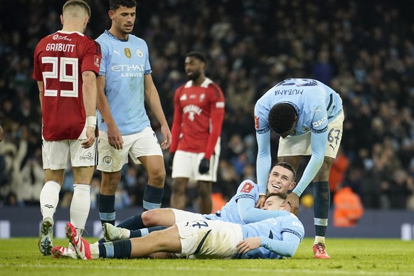 Manchester City&#039;s James McAtee, bottom, celebrates with teammates after scoring his side&#039;s eighth goal during the English FA Cup soccer match between Manchester City and Salford City at Etih ...