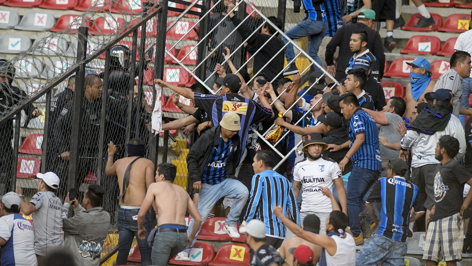 Fans clash during a Mexican soccer league match between the host Queretaro and Atlas from Guadalajara, at the Corregidora stadium, in Queretaro, Mexico, Saturday, March 5, 2022. Multiple people were i ...