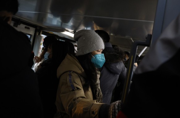 epaselect epa10439492 A woman wears a mask inside a public bus in Beijing, China, 30 January 2023. People returned to work after millions travelled for the Chinese Lunar New Year holiday as COVID-19 m ...