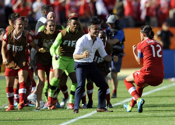 epa04787220 Christine Sinclair (R) of Canada celebrates her winning goal against China with head coach John Herdman (C) during the FIFA Women&#039;s World Cup 2015 group A match between Canada and Chi ...