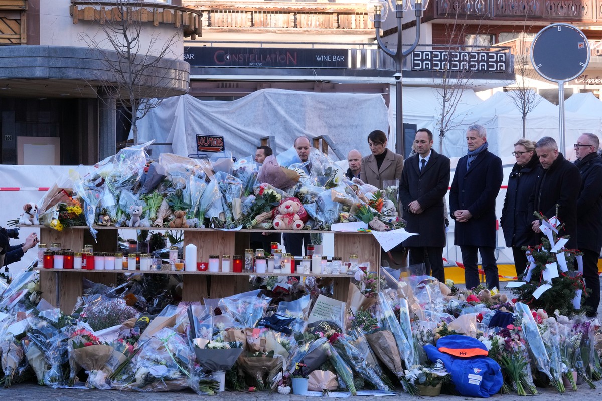 Swiss Minister of Justice Beat Jans and State Councillor Mathias Reynard lay flowers at the sealed off Le Constellation bar in Crans-Montana, Swiss Alps, Switzerland, Saturday, Jan. 3, 2026, where a d ...