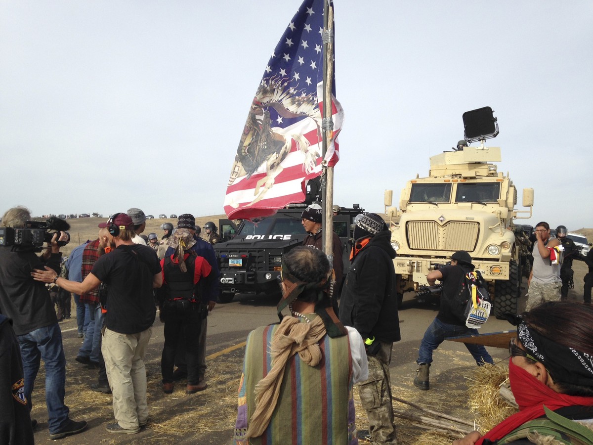 FILE - Dakota Access pipeline protesters defy law enforcement officers who are trying to force them from a camp on private land in the path of pipeline construction, Oct. 27, 2016, near Cannon Ball, N ...