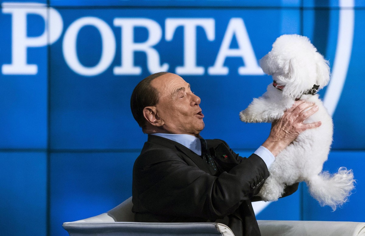epa10686572 (FILE) Italian former prime minister and leader of 'Forza Italia' party Silvio Berlusconi plays with a dog during the recording of Rai TV program 'Porta a Porta' in Rom ...