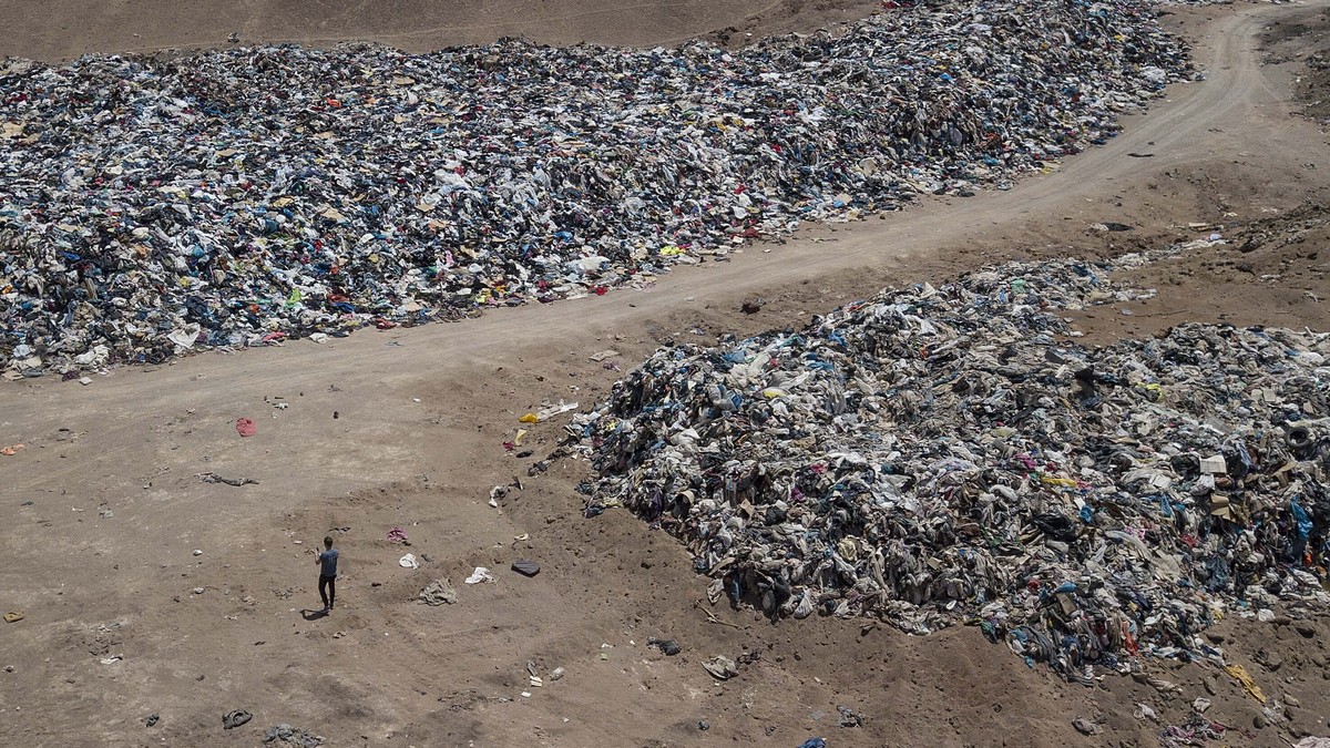 A large pile of second-hand clothing covers the sand near La Mula neighborhood in Alto Hospicio, Chile, Monday, Dec. 13, 2021. Chile is a big importer of second hand clothing, and unsold clothing gets ...