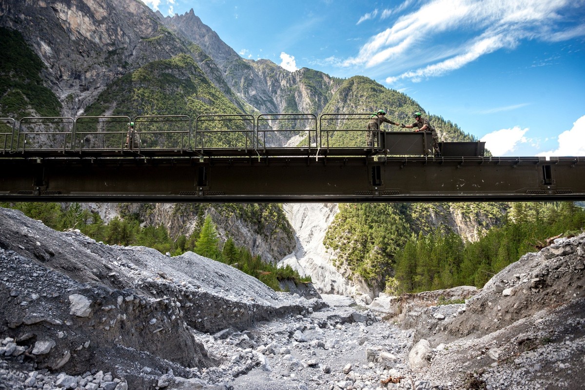 Nach dem Unwetter in der Gemeinde Scuol richten Armeeangehörige eine Unterstützungsbrücke ein.