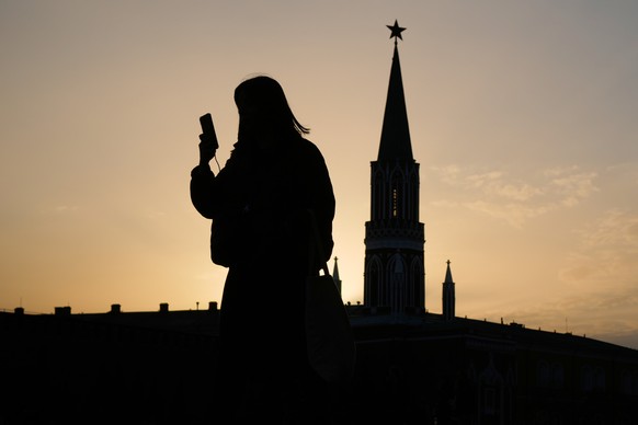 FILE - A woman checks her phone as she walks through Red Square at sunset, in Moscow, Tuesday, March 31, 2026. (AP Photo/Pavel Bednyakov, File)
Russia Internet Clampdown