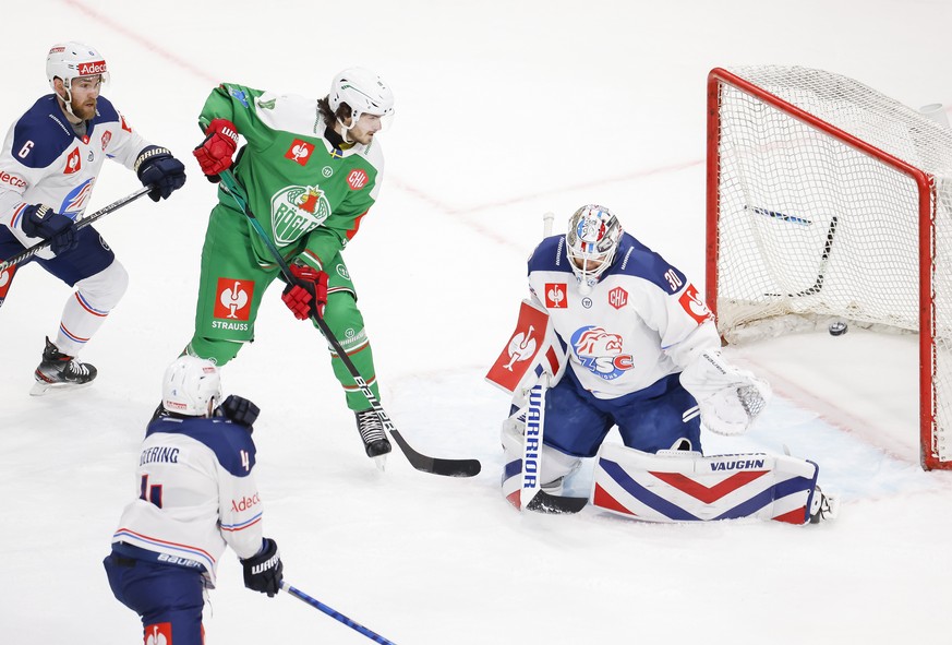 ZSC Lions goalkeeper Lukas Flueeler, right, misses a puck by Roegle BK&#039;s Adam Tambellini, not pictured, next to Roegle BK&#039;s Dennis Everberg, center, during the Champions Hockey League match  ...
