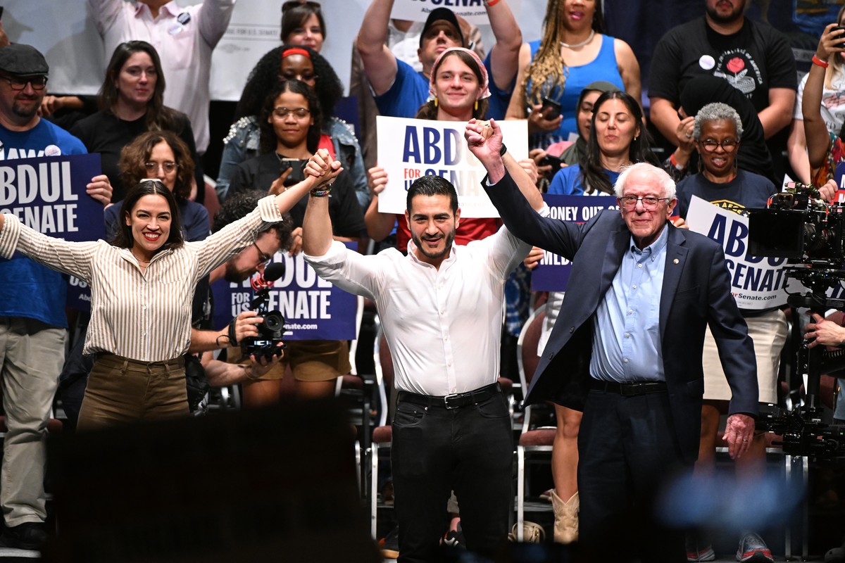 From left foreground, U.S. Rep. Alexandria Ocasio-Cortez, D-N.Y., Michigan Democratic U.S. Senate primary candidate Abdul El-Sayed, and U.S. Sen. Bernie Sanders, I-VT. join hands together following a  ...