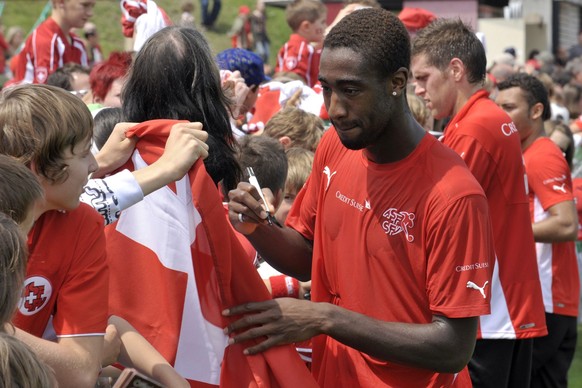 From left: Swiss national soccer players Johan Djourou and Benjamin Huggel sign autographs after a public training session of Swiss national soccer team during the Euro 2008 European Soccer Championsh ...