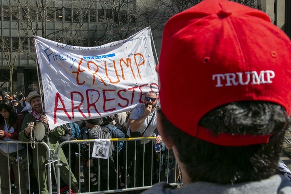 epa10558390 Protesters rally in Collect Pond Park for and against former US President Donald J. Trump before he arrives at the District Attorney's office to be arraigned in New York, New York, U...