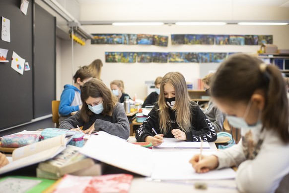 Kinder mit Atemschutzmasken im Unterricht im Schulhaus Fluntern, aufgenommen am Montag, 25. Januar 2021 in Zuerich. Schuelerinnen und Schuelern ab der 4. Klasse muessen Masken tragen um die Ausbreitun ...