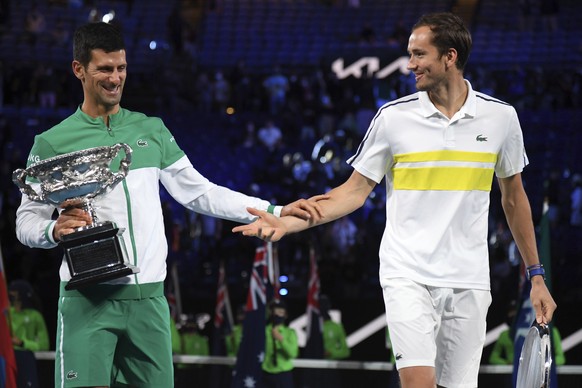 Serbia&#039;s Novak Djokovic, left, holds the Norman Brookes Challenge Cup as he talks with runner-up Russia&#039;s Daniil Medvedev after winning the men&#039;s singles final at the Australian Open te ...