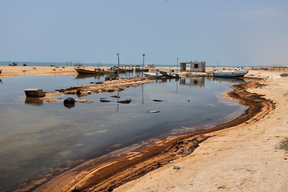 Oil residue lines the shore near fishing boats on Qeshm Island, Iran, Thursday, Aug. 13, 2026, amid ongoing wartime attacks on vessels and infrastructure in and around the Strait of Hormuz, though the ...