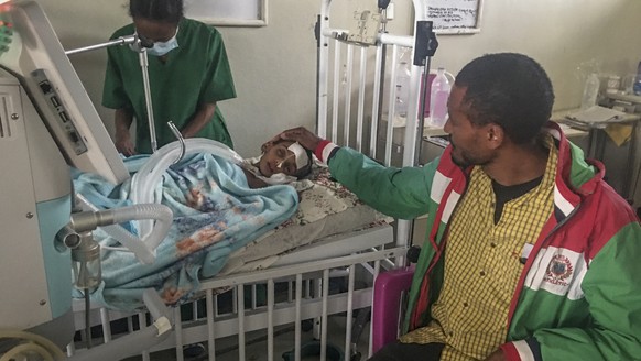 FILE - In this photo provided anonymously, Rahwa Mehari, 4, is comforted by her father who says she first suffered from malnutrition and medical records show then developed a cerebral tuberculoma, at  ...