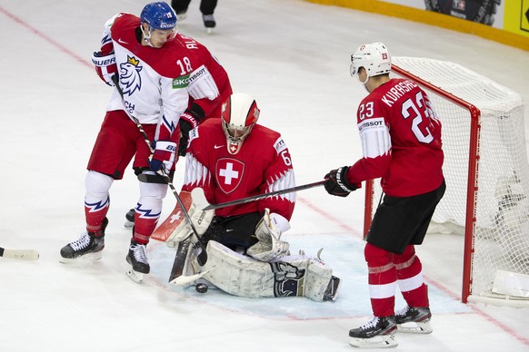 Switzerland&#039;s goaltender Leonardo Genoni, center, saves a puck past Czech Republic&#039;s forward Dominik Kubalik, left, and Switzerland&#039;s forward Philipp Kurashev, right, during the IIHF 20 ...