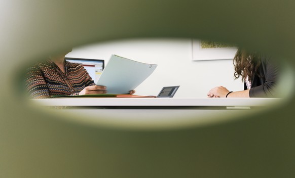 ARCHIVBILD ZU DEN ZAHLEN ZUR SOZIALHILFE 2016 --- A consultation meeting photographed through the back of a chair in an office of the social center Albisriederhaus on Albisriederstrasse in Zurich, Swi ...