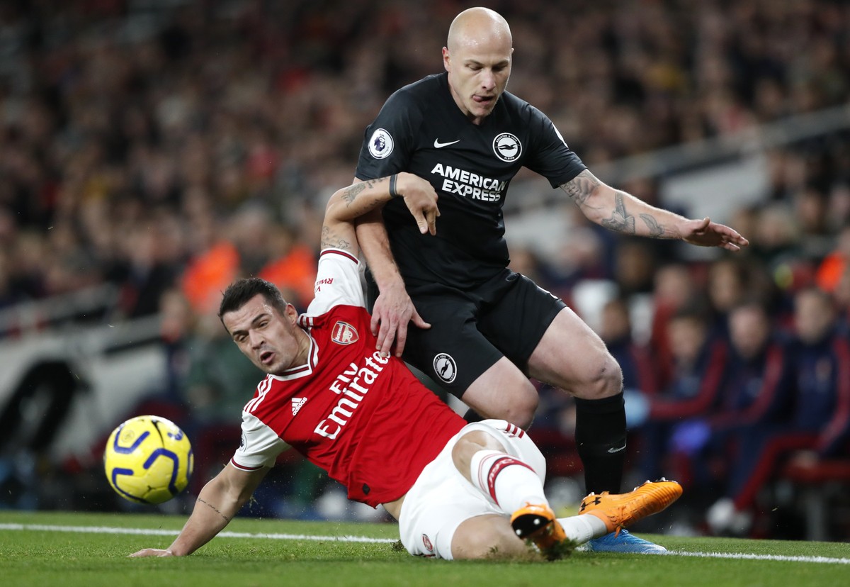 Brighton's Aaron Mooy, right, challenges Arsenal's Granit Xhaka, left, during their English Premier League soccer match between Arsenal and Brighton, at the Emirates Stadium in London, Thurs ...