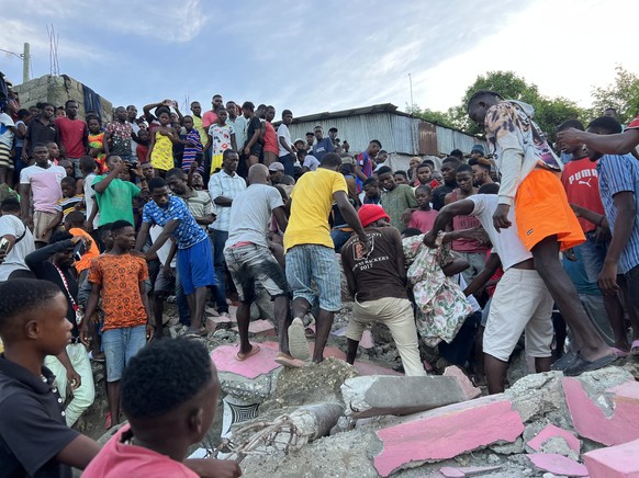 epa10676340 Residents pull the body of a victim from under the rubble after a magnitude 4.9 earthquake struck Jeremie, Haiti, June 6, 2023. At least three people died and several were injured in the quake.  E...