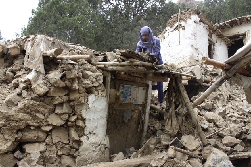 An Afghan villager collects his belongings from under the rubble of his home that was destroyed in an earthquake in the Spera District of the southwestern part of Khost Province, Afghanistan, Wednesda ...