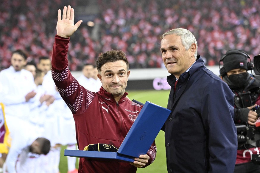 epa09583868 Swiss national soccer team director Pierluigi Tami (R) congratulates Switzerland's Xherdan Shaqiri (L) for his 100th international match before the FIFA World Cup 2022 group C qualify ...