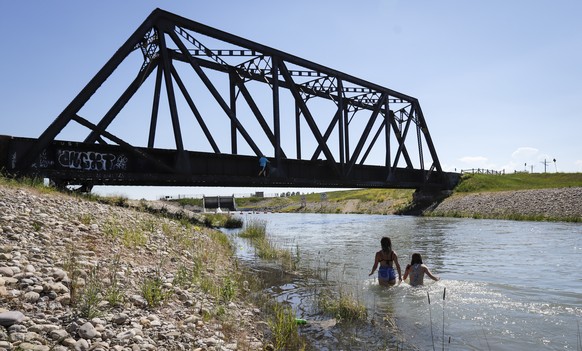 Young people try to beat the heat in an irrigation canal in Chestermere, Alta., Tuesday, June 29, 2021. Environment Canada warns the torrid heat wave that has settled over much of Western Canada won&# ...