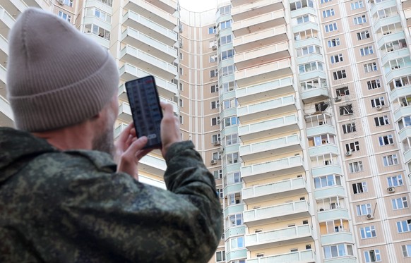 epa12966848 A person photographs a damaged apartment building following a drone attack outside Moscow, Russia, 17 May 2026. According to Russian authorities, at least three people were killed in overn ...
