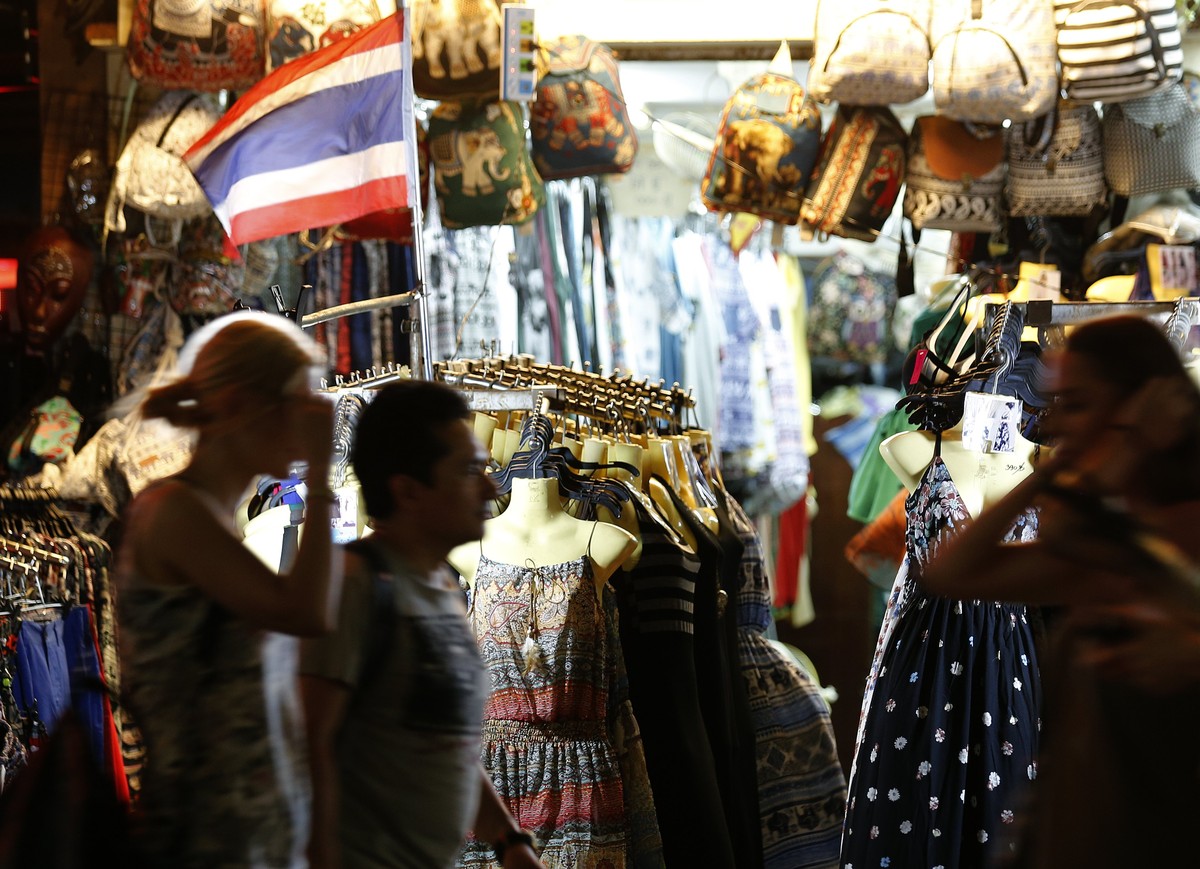 epa05918570 Tourists walk past a clothes shop at the popular backpacker street Khao San road in Bangkok, Thailand, 20 April 2017 (issued 21 April 2017). The Tourism Authority of Thailand (TAT) conclud ...