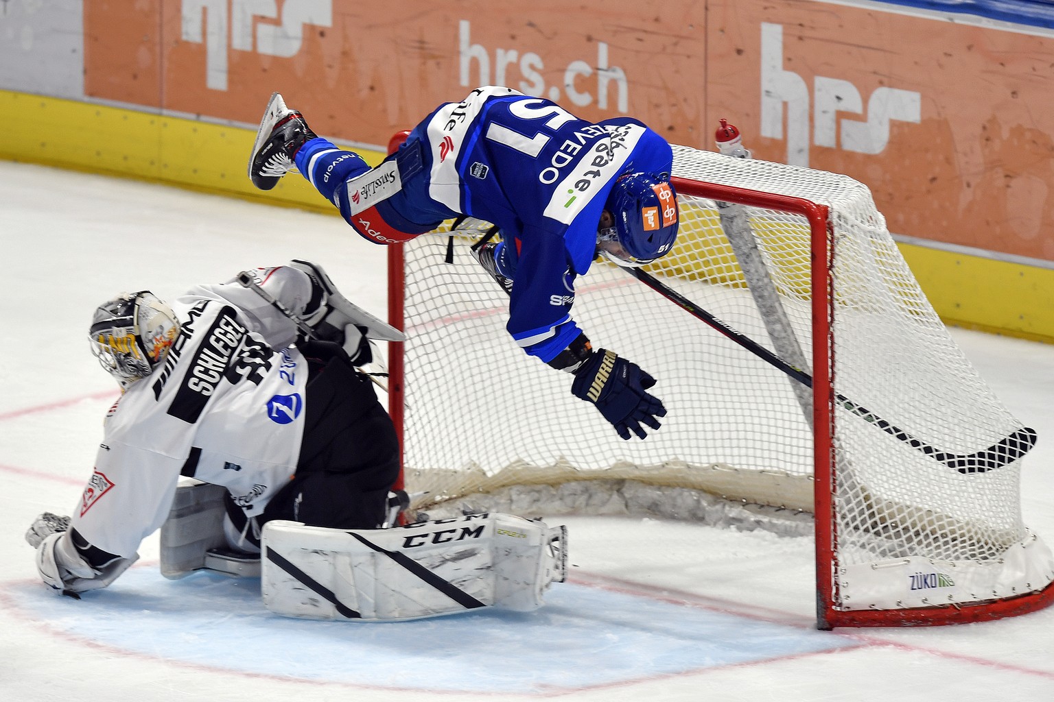 Der Zuercher Justin Azevedo, rechts, beim Sturzflug ueber den Tessiner Torhueter Niklas Schlegel, links, beim Eishockeyspiel der National League ZSC Lions gegen den HC Lugano im Zuercher Hallenstadion ...