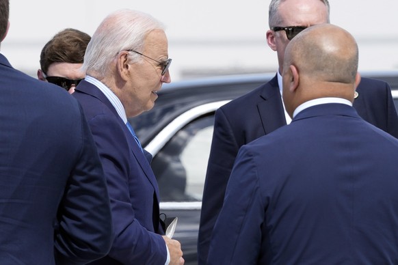 President Joe Biden carries a face mask in his hand as he walks to board Air Force One at Harry Reid International Airport in Las Vegas, Wednesday, July 17, 2024. Biden has tested positive for the cor ...