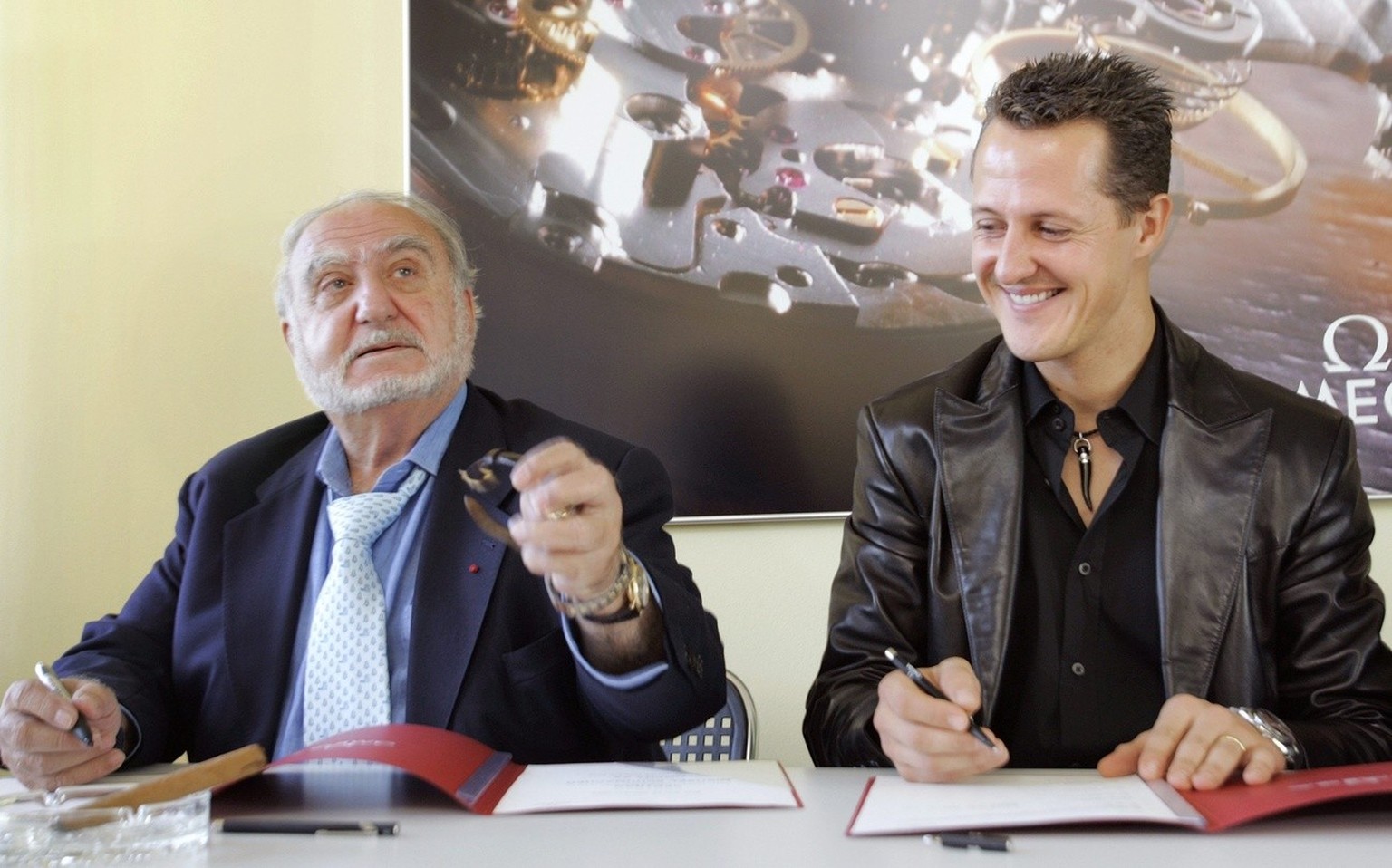 Seven-times Formula 1 World Champion Michael Schumacher, right, and Nicolas G. Hayek from Switzerland, Chairman of the Board of Swatch Group, sign the extension of the partnership between the German p ...
