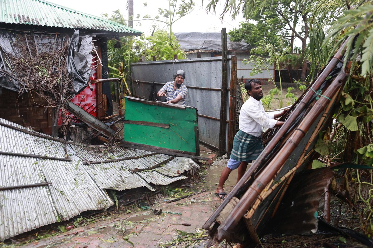 epa10627476 People check their damage house after cyclone Mocha's landfall at the Shahpori Dwip, Teknuf area near Cox's Bazar, Bangladesh, 14 May 2023. Powerful cyclone Mocha made landfall m ...