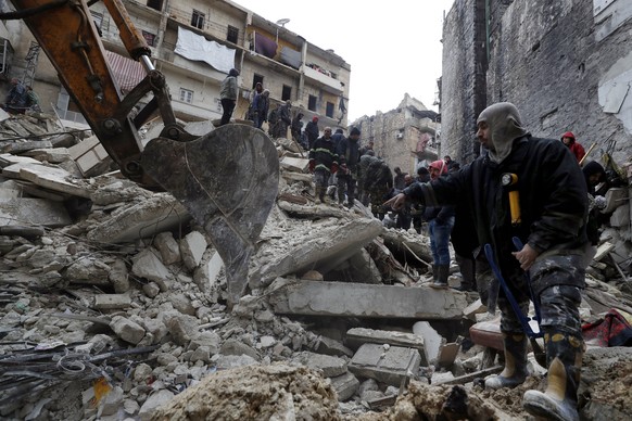 FILE - Syrian Civil Defense workers and security forces search through the wreckage of collapsed buildings after a devastating earthquake rocked Syria and Turkey, in Aleppo, Syria, Monday, Feb. 6, 202 ...