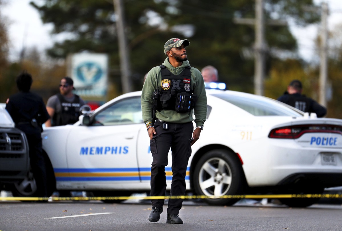 A Memphis Police officer surveys the scene of a fatal shooting involving the rapper Young Dolph, Wednesday, Nov. 17, 2021, in Memphis, Tenn. Dolph was shot and killed Wednesday at a cookie shop in his ...