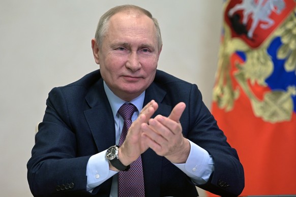 Russian President Vladimir Putin applauds as he attends a cabinet meeting via video conference at the Novo-Ogaryovo residence outside Moscow, Russia, Friday, Dec. 24, 2021. (Alexei Nikolsky, Sputnik,  ...