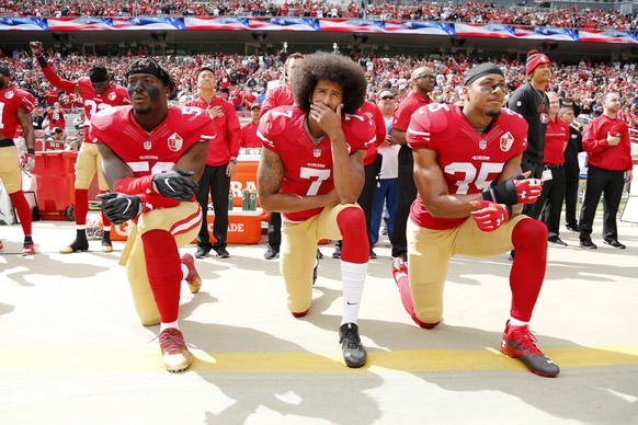 epa08095875 PICTURES OF THE DECADE ..San Francisco 49ers back-up quarterback Colin Kaepernick (C), San Francisco 49ers outside linebacker Eli Harold (L), and San Francisco 49ers free safety Eric Reid  ...