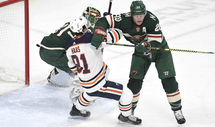 Minnesota Wild&#039;s Ryan Suteri, right, pushes Edmonton Oilers&#039; Gaetan Haas, left, of Switzerland, away for the goal in the first period of an NHL hockey game, Thursday, Dec.12, 2019, in St. Pa ...