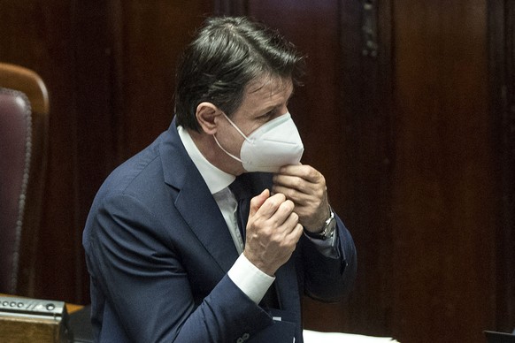 Italian Premier Giuseppe Conte adjusts his face mask as he arrives at the Lower Chamber of Deputies of the Italian Parliament, in Rome, Tuesday, April 21, 2020. Conte said the easing of lockdown restrictions for Italy's devastating COVID-19 outbreak will be gradual and evenly distributed throughout the country. Italians have been eagerly awaiting to learn what limits they still will have on their personal, social and work life after the government decree on restrictive measures expires on May 3. (Roberto Monaldo/LaPresse via AP)