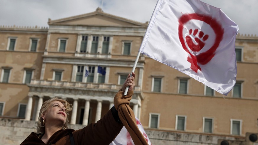 A woman waves a flag depicting a symbol of feminism during a march to celebrate International Women&#039;s Day in Athens March 8, 2014. On March 8 activists around the globe celebrate International Wo ...