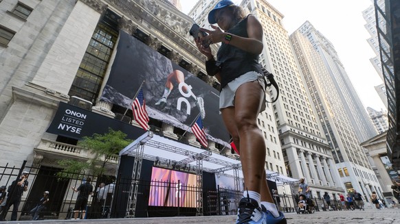 A woman wears On shoes outside the New York Stock Exchange before the company&#039;s IPO, Wednesday, Sept. 15, 2021. (AP Photo/Richard Drew)