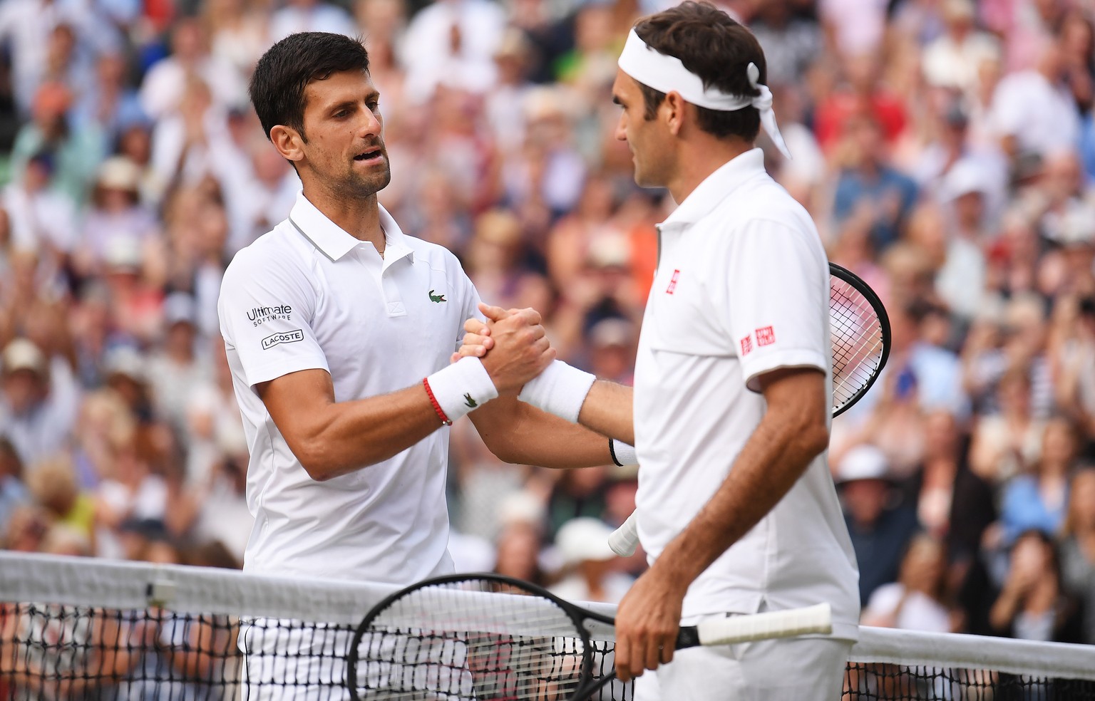 epa07717344 Novak Djokovic (L) of Serbia celebrates winning against Roger Federer (R) of Switzerland during their Men&#039;s final match for the Wimbledon Championships at the All England Lawn Tennis  ...