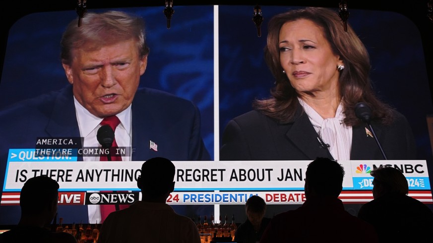 People watch the presidential debate between Republican presidential nominee former President Donald Trump and Democratic presidential nominee Vice President Kamala Harris, Tuesday, Sept. 10, 2024, at ...