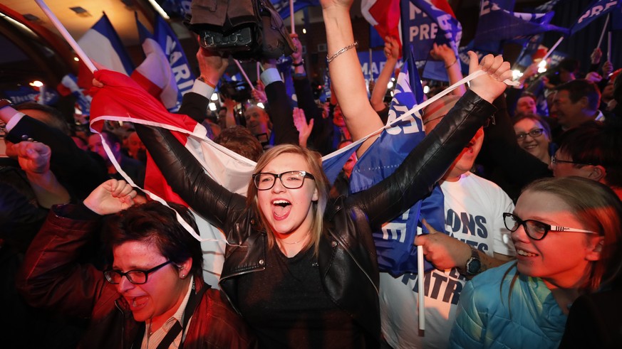 Supporters of far-right leader and candidate for the 2017 French presidential election, Marine Le Pen, celebrate after exit poll results of the first round of the presidential election are announced a ...