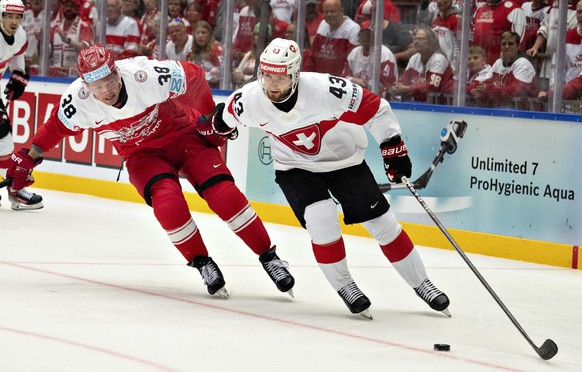 epa12089696 Morten Poulsen of Denmark in action against Andrea Glauser of Switzerland during the 2025 IIHF Ice Hockey World Championship group B match between Denmark and Switzerland in Herning, Denma ...