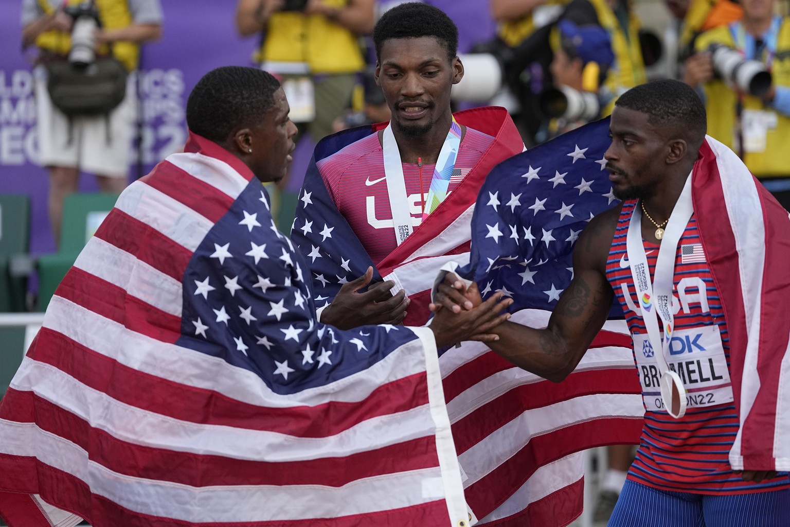 Gold medalist Fred Kerley, of the United States, center, stands with silver medalist Marvin Bracy, of the United States, right, and bronze medalist Trayvon Bromell, of the United States, speak after t ...