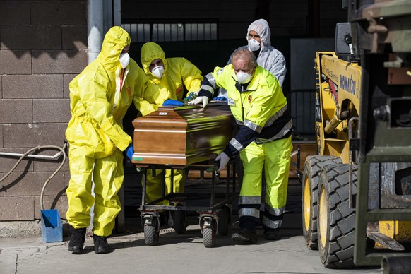 epa08328881 Italian Carabinieri officers, along with the Army and Civil Protection members, load the coffins of people deceased because of the coronavirus on military funeral cars, in Ponte San Pietro ...