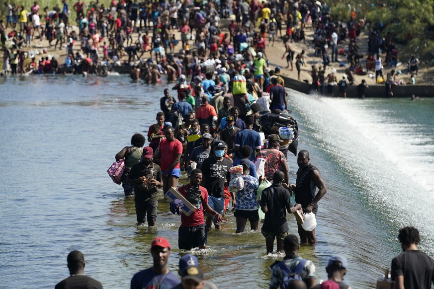 Haitian migrants use a dam to cross to and from the United States from Mexico, Friday, Sept. 17, 2021, in Del Rio, Texas. (AP Photo/Eric Gay)