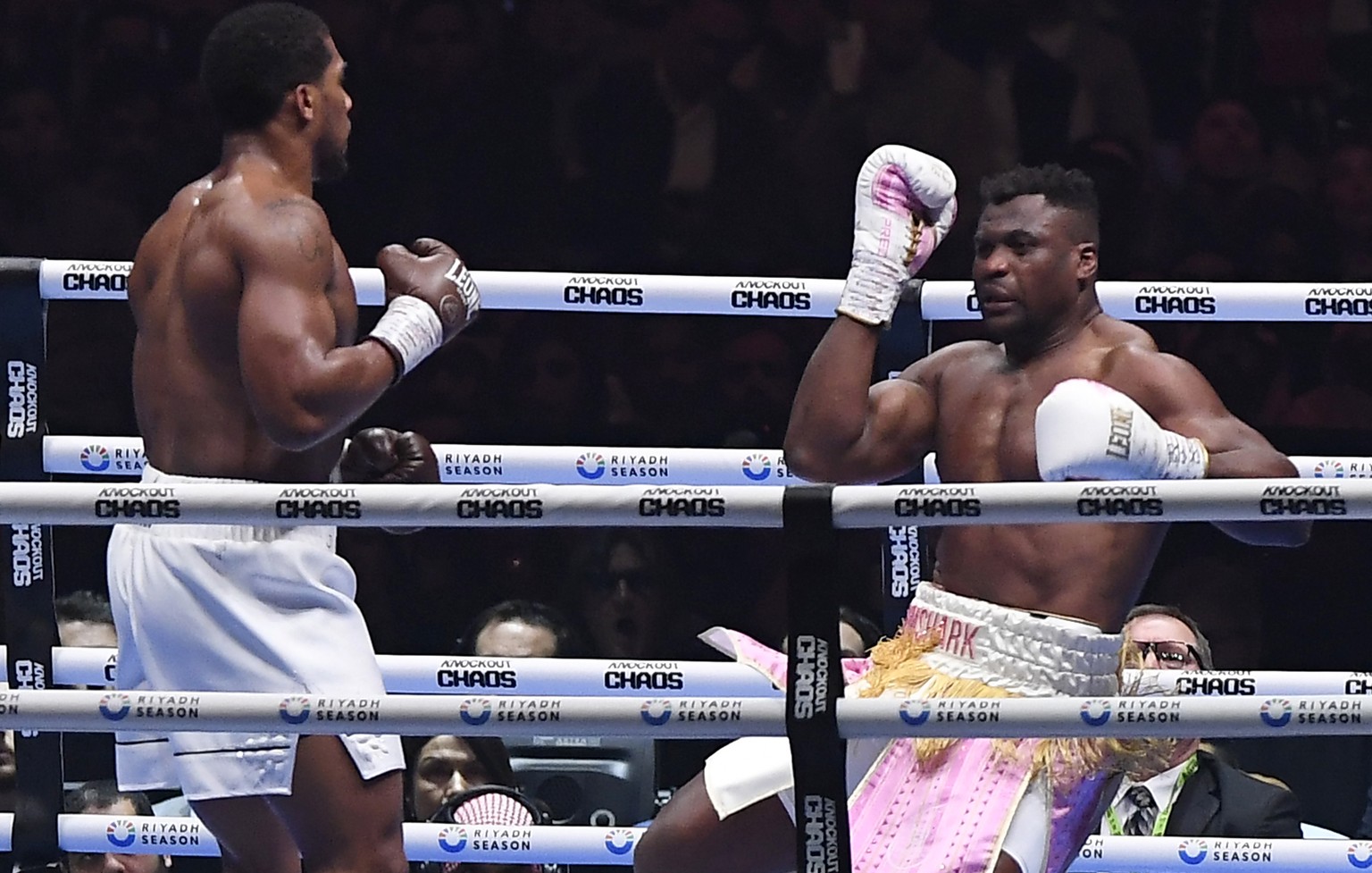 MMA fighter Francis Ngannou, right, falls during his fight with British former world champion Anthony Joshua, of the heavyweight boxing showdown at Kingdom Arena in Riyadh, Saudi Arabia, Saturday, Mar ...