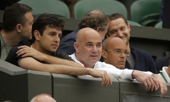 Mario Antic, left, and Andre Agassi, center, coaches of Serbia&#039;s Novak Djokovic take their seats before he plays his Men&#039;s Singles Match against Adrian Mannarino of France on day eight at th ...